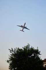 A plane flying low over the houses. The proximity of urban development to the airport.