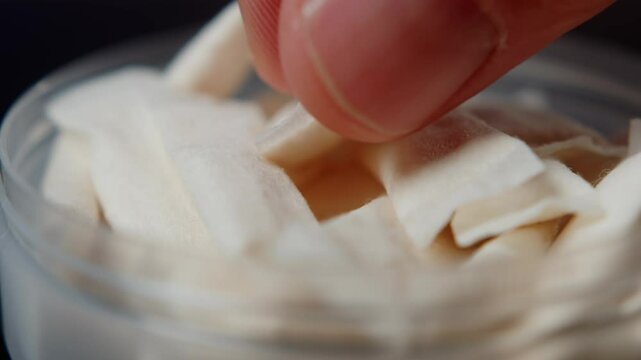 Snus nicotine tobacco close up, pack of tobacco for gum. unhealthy addiction. Man opening box with snus and taking one. 