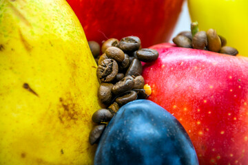 Coffee beans scattered on fruit close-up	
