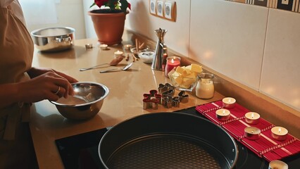 Cozy kitchen baking scene with holiday cookie preparation and candles