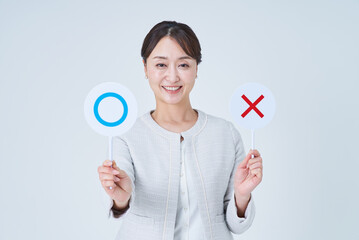 マルとバツのプレートを持つビジネスウーマン