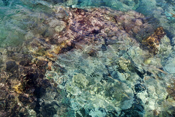 Abstract background with transparent ocean water over rocky bottom