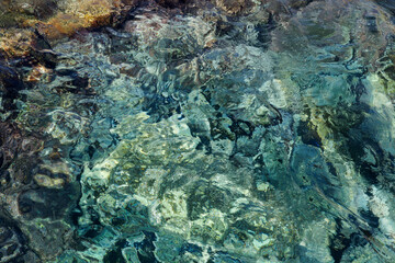 Abstract background with transparent ocean water over rocky bottom