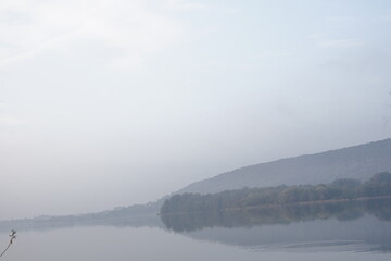 misty morning on the Lake Comabbio , very early in the morning, from the promenade of the lakefront of Varano Borghi. Italy