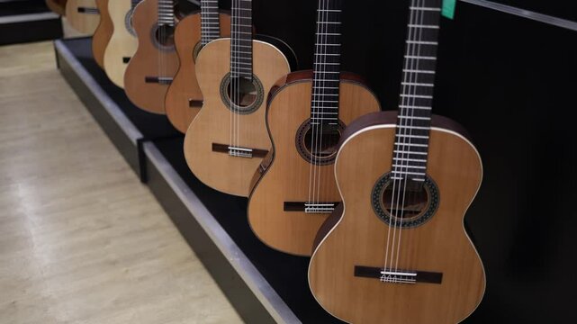 A row of classical acoustic guitars with warm wooden tones and intricate rosette designs, beautifully arranged for display. These timeless instruments make it hard to decide which one to choose.