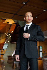 Confident businessman in suit waiting in blurred office lobby