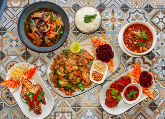 Thai food, multiple dishes hero shot with curry, chicken satay starter and main course