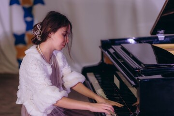 Classic perfection. Shot of a beautiful young woman playing the piano in an elegant room.
