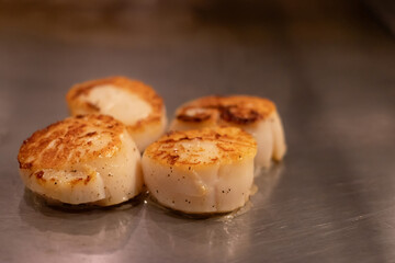 Deliciously seared scallops on hot pan.