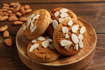 Tasty cookies with almond flakes and nuts on wooden table, closeup