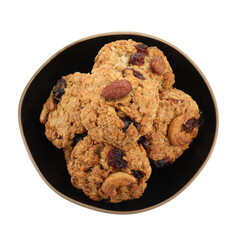 Delicious oatmeal cookies with dried cranberries and nuts in bowl isolated on white, top view