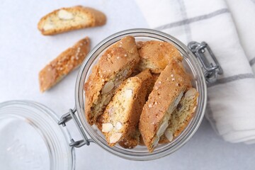 Traditional Italian almond biscuits (Cantucci) in jar on light table, top view