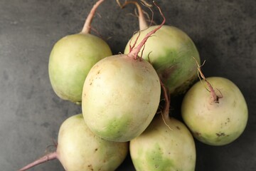 Whole fresh ripe turnips on grey table, top view