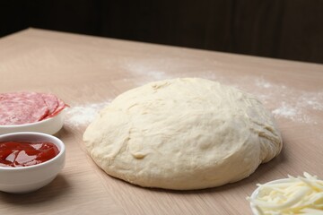Making calzone pizza. Dough and ingredients on wooden table