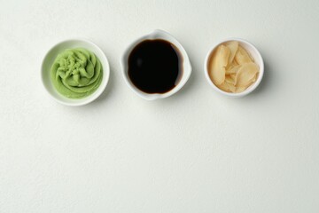 Hot wasabi paste, soy sauce and ginger on light textured table, flat lay. Space for text