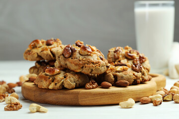 Tasty cookies with nuts on white wooden table, closeup