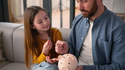 Happy Caucasian family little schoolgirl child girl daughter kid saving money at home guy parent dad male father man put coins in piggy bank savings economy financial education invest charity donation - Powered by Adobe