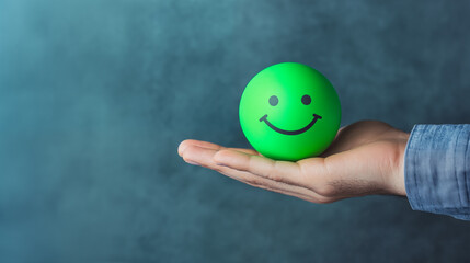 Customer service evaluation, customer satisfaction good level and satisfaction survey concept. Man hand holds a green smiling ball, isolated in a blue background