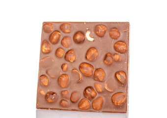 One bar of dark chocolate with hazelnuts, close-up, isolated on a white background.