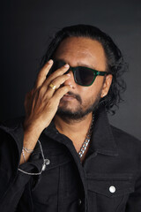 Gangster Boss wearing sunglasses, holding his hand, ring finger, black shirt, isolated over black background, stock images.