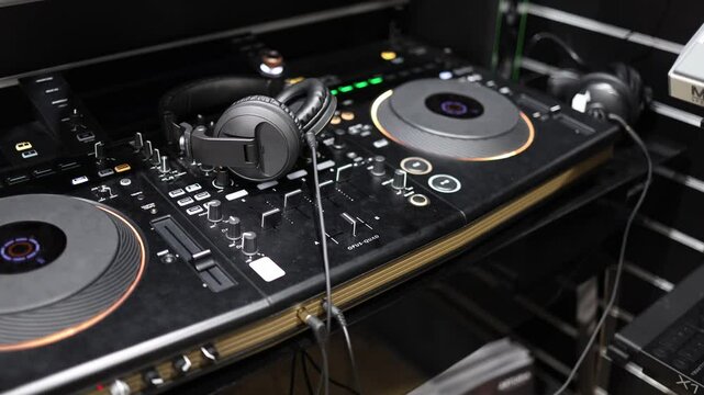 A sleek DJ controller equipped with illuminated jog wheels and comprehensive controls, paired with professional headphones. This setup is ideal for DJs aiming for precision and dynamic performances.