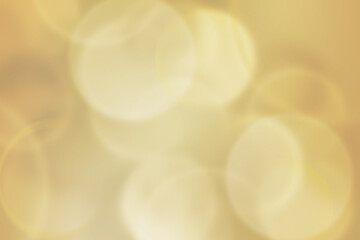 Softly golden bokeh and gentle flare allure for elegant concept background.