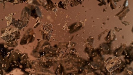 Freeze motion of flying group of raw chocolate pieces.