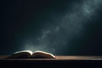 Open book lying on wooden table with smoke in background