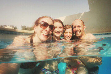 Family Selfie of a Mum, Dad and two teen daughters in a swimming pool