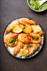  Fried shrimps with lemon and green in a plate, top view, copy space for text