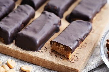 Homemade healthy bars made of whey protein powder, dates and peanut butter coated in chocolate