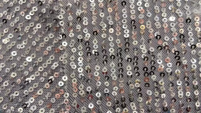 Silver sequin fabric with shimmering highlights luxurious textured background for design.Holiday abstract glitter texture with blinking lights,4K video