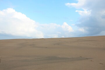 sand dunes of the desert and the sky with a few clouds, without people