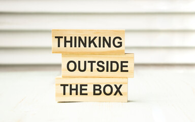 Thinking outside the box text on wooden block.