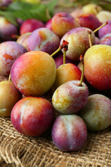 Pile of tasty ripe plums on table, closeup