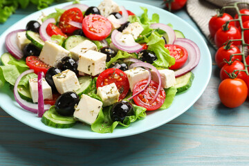 Delicious salad with feta cheese served on blue wooden table, closeup