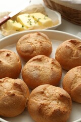 Baking dish with homemade tasty buns on table, closeup