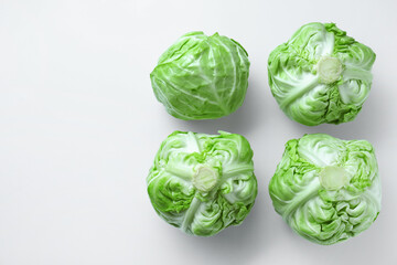 Fototapeta premium Raw green cabbages on white background, flat lay. Space for text