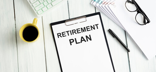 Text Retirement Plan is on the white paper with coffee, calculator and ball pen aside.
