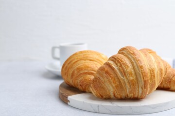 Tasty fresh croissants on light table, closeup. Space for text