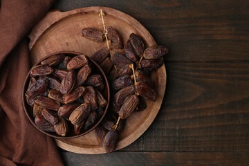 Tasty dried dates on wooden table, top view