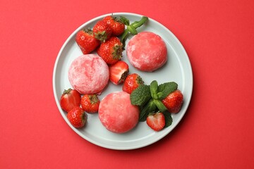 Delicious mochi, strawberries and mint on red background, top view