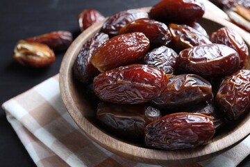 Tasty dried dates on black table, closeup