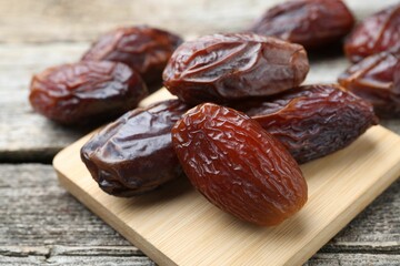Many tasty dried dates on wooden table, closeup
