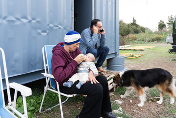 Grandmother feeding baby while businessman is making a call