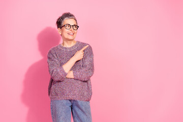 Photo of charming positive woman wear sweater smiling looking showing empty space isolated pink color background