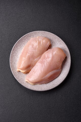 Fototapeta premium Pieces of raw chicken or turkey fillet with salt, spices and herbs