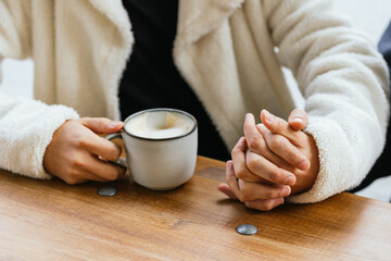 Gay couple holding hands and drinking cappuccino at coffee shop