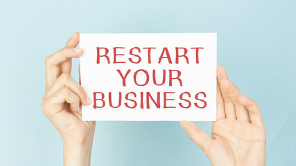 Hands hold a card with the text 'restart your business'