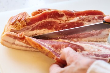 Close-up of bacon during the preparation, cutting and cooking process